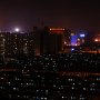 In the distance, skyscrapers from downtown Hohhot illuminate the night sky.